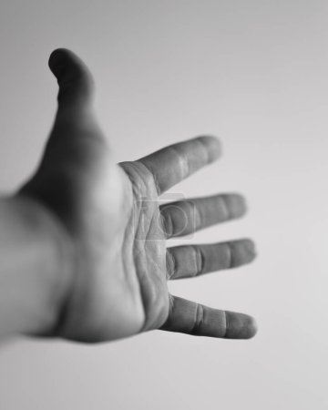 Eine menschliche Hand, die sich mit ausgestreckten Fingern ausstreckt, schafft ein Gefühl von Bewegung und Perspektive