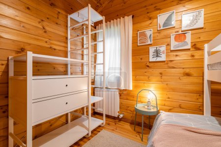 Children bedroom with bunk bed, open wardrobe and wooden walls. Cozy and comfortable cottage interior