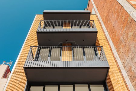 Photo for Bottom view of contemporary building facade. Outdoor exterior of narrow modern house with windows and balconies in Barcelona, Spain. - Royalty Free Image