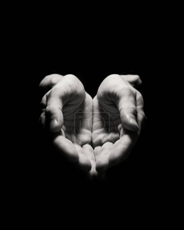 Foto de Dos manos abiertas mirando hacia arriba en un fondo oscuro, lo que implica una ofrenda o gesto - Imagen libre de derechos