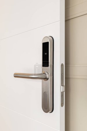 Nahaufnahme der Türklinke mit digitalem Schloss an der weißen Tür am Eingang eines Hotelzimmers. Konzept eines modernen Schutzsystems und einer modernen Technologie zur Erleichterung des Lebens.