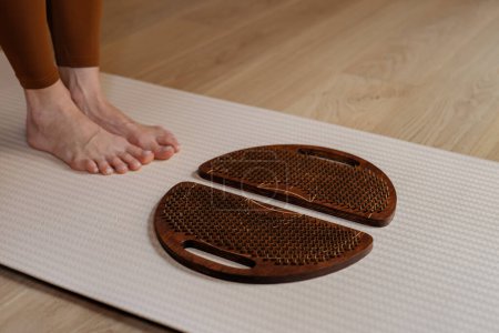 Anticipándose al toque terapéutico, los pies se ciernen sobre tablas de sadhu en una colchoneta de yoga calmante.