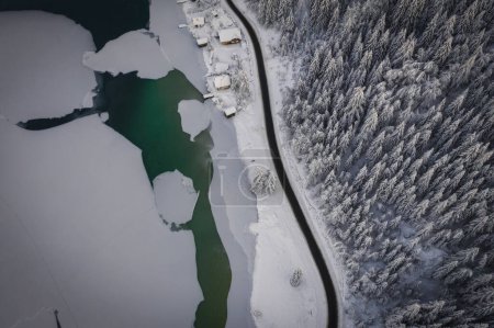Photo for A top down, drone capture of Weissensee lake in Austrian Alps. Ice and green water. A small settlement at the shore. A bit of overcast. Serenity and peacefulness. January 2022 - Royalty Free Image