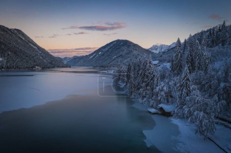 Téléchargez les photos : Le cadre magnifique du parc naturel de Weissensee. Lac gelé Weissensee, Carinthie, Alpes, Autriche. Drone aérien tiré en janvier 2022. Heure du coucher du soleil. - en image libre de droit