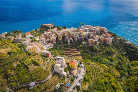 Corniglia village with colorful houses Cinque Terre is a famous seaside attraction. On the shores of the Ligurian Sea high above the cliffs in northwestern Italy. Sunny september 2022 aerial view.