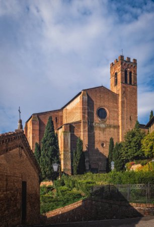Siena, Tuscany, Italy: cityscape with the medieval church Basilica of San Domenico on the hill in the old town of the city. October 2022