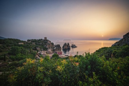 Acantilados en la costa en verano en Scopello cerca de Castellammare del Golfo en Sicilia, Italia. Junio 2023, imagen de exposición larga, hora del amanecer.