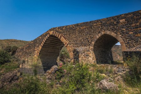 Foto de Ponte dei Saraceni. Un antiguo puente medieval de la edad normanda situado en el río Simeto. Adrano - Catania, en Sicilia. Imagen de larga exposición. Junio de 2023 - Imagen libre de derechos