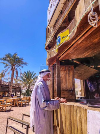 Foto de Viejo beduino con barba blanca de pie junto a la barra de café - Imagen libre de derechos