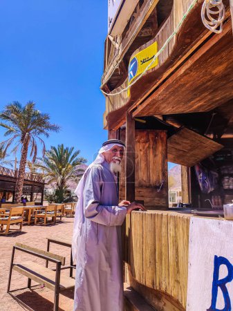 Foto de Viejo beduino con barba blanca de pie junto a la barra de café - Imagen libre de derechos