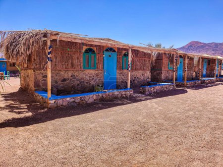 Photo for Cottage in a Bedouin Camp on the Sea in Ras Shitan in Oasis in Sinai, Taba desert with the Background of the Sea and Mountains. - Royalty Free Image