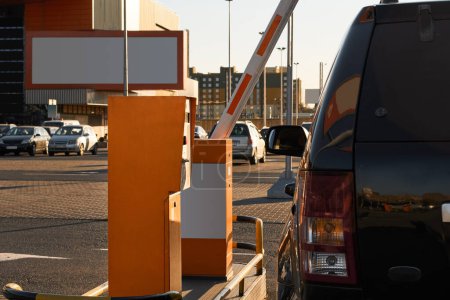Auto nähert sich automatischen Schranken für Supermarktparkplätze. Fahrzeugeinfahrt mit Leitplanken und Fahrkartenautomaten. Sicherheitssystem für Parkplatzeinfahrt in Einkaufszentrum