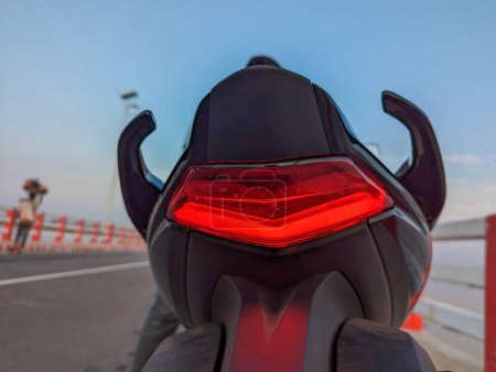 Nahaufnahme des Rücklichts eines Motorrads, Detailansicht des Rücklichts eines Motorrads, das seine Design- und Beleuchtungselemente präsentiert.