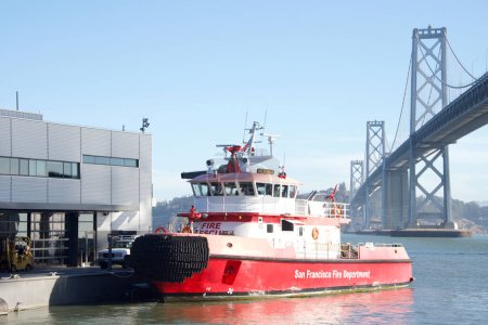 Foto de San Francisco, CA - 27 de octubre de 2022: San Francisco es un barco de bomberos operado por el Departamento de Bomberos de San Francisco en la Bahía de San Francisco desde 2016. También conocido como Fireboat 3. Puente de la Bahía en segundo plano. - Imagen libre de derechos