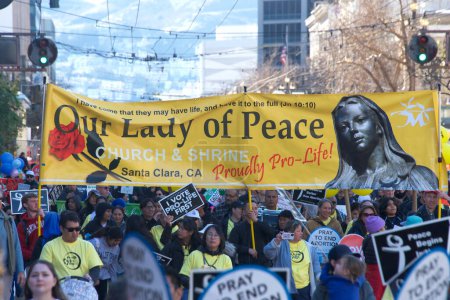Foto de San Francisco, CA - Jan 21, 2023: Unidentified participants in the annual March for Life, holding pro-life signs and banners, walking down Market street towards the Embarcadero - Imagen libre de derechos