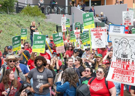 Téléchargez les photos : Oakland, CA - Le 11 mai 2023 : Des enseignants et des parents tenant des pancartes lors de la grève des enseignants Jour 6 Rassemblement devant l'école primaire Glenview. - en image libre de droit