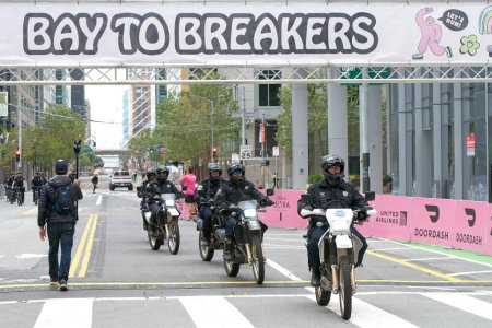 Photo for San Francisco, CA - May 21, 2023: SFPD motorcycle police clear the route for the annual Bay to Breakers race through San Francisco. - Royalty Free Image
