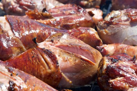 Photo for Turkey legs grilling on a BBQ grill. Giant turkey legs are a very popular food for street fair vendors. - Royalty Free Image