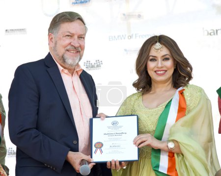 Foto de Fremont, CA - 20 de agosto de 2023: Tom Pyke, miembro del personal del Congreso Ro Khanna, entrega de un premio al Gran Mariscal Mahima Chaudhry en el 31º Festival FOG anual. - Imagen libre de derechos