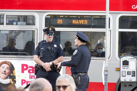 Photo for San Francisco, CA - Dec 15, 2023: Two San Francisco Police officers patrolling the city streets, Muni Bus passing behind them. - Royalty Free Image