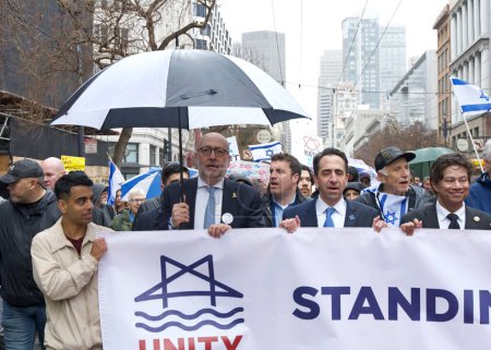 Foto de San Francisco, CA - 03 de marzo de 2024: Políticos y participantes no identificados en una Marcha Contra el Antisemitismo en la Calle Market hasta el Centro Cívico. Marchando bajo la lluvia. - Imagen libre de derechos