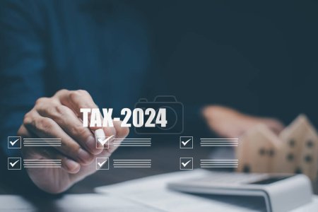 Hand using tablet with bar  TAX REFUND 2024 and refund tax of duty taxation business, graphs and chart being demonstrated on the screen media,  tablet pc and selecting tax refund.