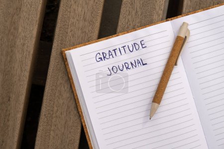 Writing Gratitude Journal on wooden bench. Today I am grateful for. Self discovery journal, self reflection creative writing, self growth personal development concept. Self care wellbeing spiritual