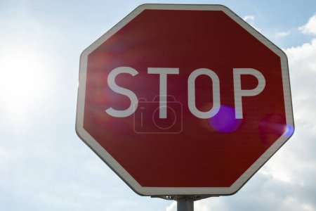 Téléchargez les photos : Red stop sign on metal pole on street. Road attention sign on cloudy background. Outdoors - en image libre de droit