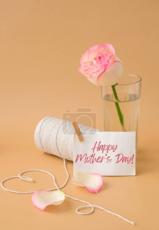Foto de HAPPY MOTHERS DAY text Tender pink roses with spool of white cotton rope in heart shape on beige background. Romantic pastel pink rose flowers. Neutral earth tones. Greeting card holiday - Imagen libre de derechos
