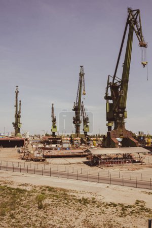 Photo for Industrial building at the Gdansk Shipyard, former Lenin Shipyard, prefabrication workshop and heavy cranes large Polish shipyard. Cranes at historical shipyard in Gdansk headquarters of Solidarity - Royalty Free Image