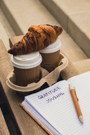 Photo for Writing Gratitude Journal on wooden bench. Coffee and croissants morning routine. Today I am grateful for. Self discovery journal, self reflection creative writing, self growth personal development - Royalty Free Image