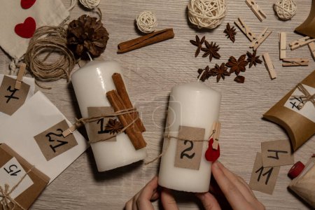 Téléchargez les photos : Unrecognizable young woman paint numbers on candles. Female making homemade advent calendar Made with your own hands step by step DIY crafts do it yourself. Preparation to christmas concept. Seasonal activities for children family winter holidays. Ec - en image libre de droit