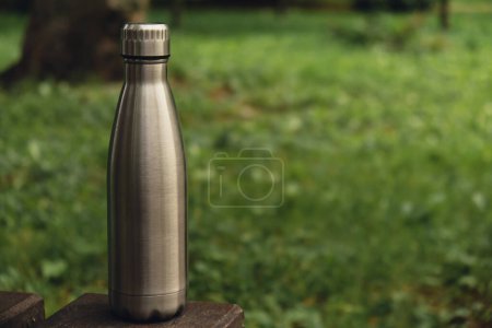 Foto de Water bottle. Reusable steel thermo water bottle on green grass. Sustainable lifestyle. Plastic free zero waste free living. Go green Environment protection. Health-conscious. Steel thermo water bottle of silver, on background of blurred grass. - Imagen libre de derechos