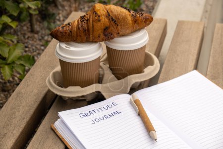 Schreiben Dankbarkeit Journal auf Holzbank. Kaffee und Croissants Morgenroutine. Heute bin ich dankbar dafür. Selbstfindungstagebuch, Selbstreflexion kreatives Schreiben, Selbstentwicklung persönliche Entwicklung