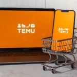 Gdansk, Poland - March 2023 Temu app icon in screen of MacBook Apple computer laptop and mobile Iphone with shopping cart. Temu subsidiary of China based e-commerce platform Pinduoduo. Online shopping