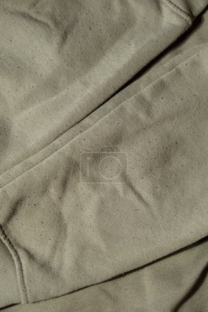 Photo for Lints on green sweater. Before cleaning and collected fluff lint. Closeup Pilled Clothes. Old used Clothes with lint pilling. Restoration of old damaged care. Repairing fabric textile reducing - Royalty Free Image