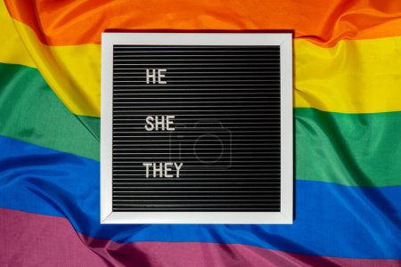 Photo for HE SHE THEY text Neo pronouns concept on Rainbow flag background gender pronouns. Non-binary people rights transgenders. Lgbtq community support assume my gender, respect pronouns tolerance equal - Royalty Free Image