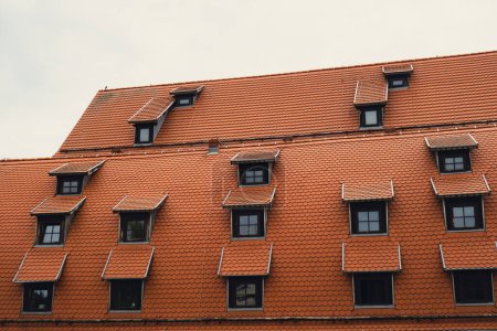 Téléchargez les photos : Coin avec lucarnes Toits rouges de la ville tuiles métalliques brun toit de la maison européenne avec fenêtres. Typique toiture européenne en brique avec fenêtres. Bydgoszcz ville - en image libre de droit