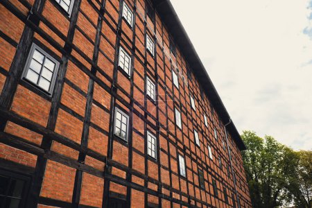 Photo for Former Rother Mills building complex made of characteristic brick and a half-timbered structure situated on the Mill Island Old town Bydgoszcz, Poland. Facade of the complex of ancient mills - Royalty Free Image