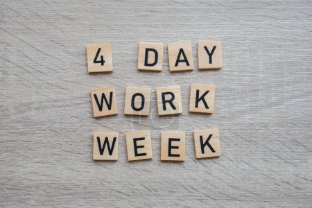 Téléchargez les photos : Symbole de semaine de travail de 4 jours sur des blocs de bois concept de semaine de travail de quatre jours. Approche moderne faisant des affaires semaine de travail courte. Efficacité des employés. Productivité et efficacité jours de congé - en image libre de droit