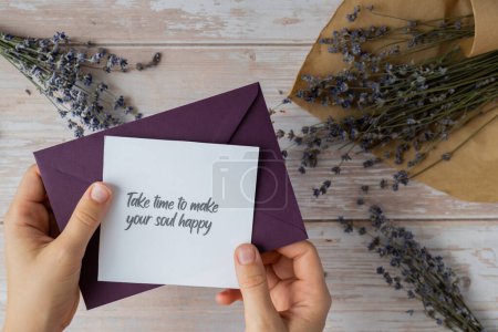 Photo for TAKE TIME TO MAKE YOUR SOUL HAPPY text on supportive message paper note reminder from green envelope. Flat lay composition dry lavender flowers. Concept of inner happiness, slowing-down digital detox personal fulfillment. Top view - Royalty Free Image