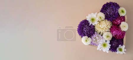 Photo for Colorful mixed flowers in shape of heart on beige background. Concept of love and valentines day, weeding, anniversary. Postcard greeting card template. Flat lay minimalistic composition - Royalty Free Image