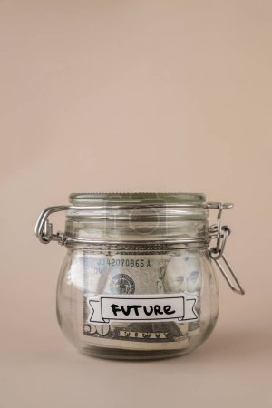 Glass jar full of American currency dollars cash banknote with text FUTURE. Preparation saving money. Moderate consumption and economy. Collecting money