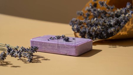 Lavender soap on beige background with copy space for your text. Advertisement template mock up. Skincare homemade natural cosmetic concept. Organic dry lavender flower. Handmade soap 