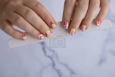 Foto de Pastel suavidad colorido manicura uñas. Mujer mostrando su nueva manicura de verano en colores pastel paleta. Simplicidad decoración fresco primavera vibraciones color tierra tonos neutros diseño - Imagen libre de derechos