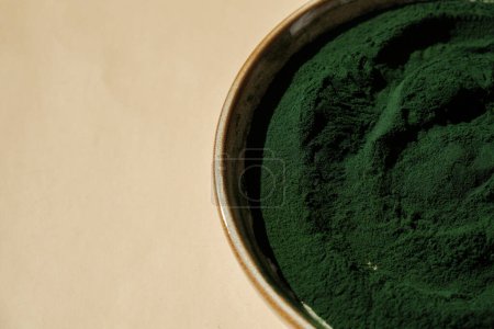 Natürliches organisches grünes Spirulina-Algenpulver in einer Schüssel auf neutralem Hintergrund. Chlorella Algen vegane Superfood Nahrungsergänzungsmittel Quelle und Entgiftung. Gesundes ernährungsphysiologisches antioxidatives Konzept 