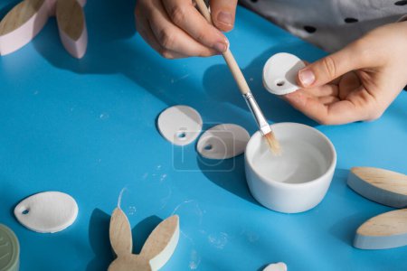 Photo for Creator is using white air dry clay for making decor to EASTER holiday. Creating hobby recreation activity that involves fingers. DIY crafting Modern art - Royalty Free Image