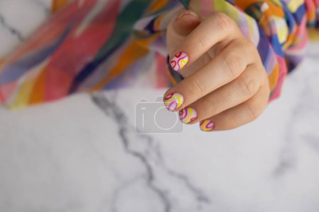 Pastel softness colorful manicured nails. Woman showing her new summer manicure in colors of pastel palette. Simplicity decor fresh spring vibes earth-colored neutral tones design