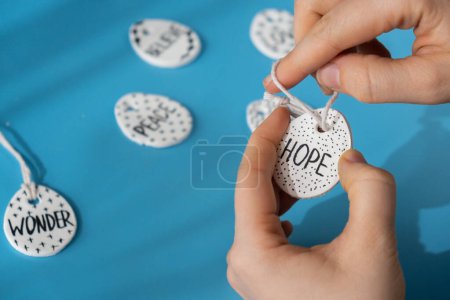 Master class word HOPE on EASTER clay egg Unrecognizable artist do it yourself air dry clay crafts for Easter holiday. Decoration gift idea Handmade children craft. Step by step instruction of