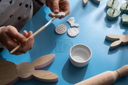Master class of painting Unrecognizable artist do it yourself air dry clay crafts for Easter holiday. Decoration gift idea Handmade children craft. Step by step instruction of painting, pressing